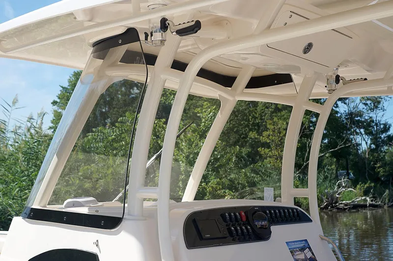 Next Level Yacht Photos Pics 2019 Grady-White Canyon 306 boat console with windshield and controls, surrounded by greenery.