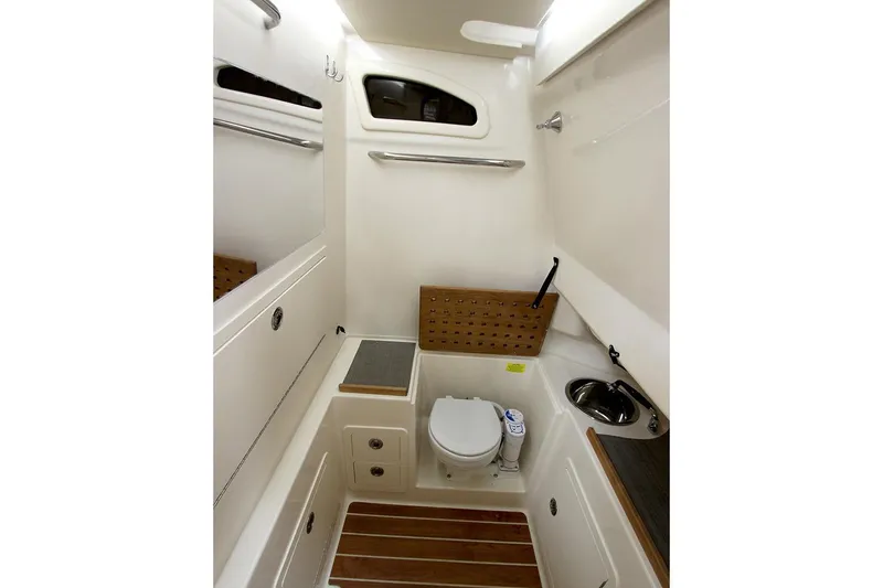 Next Level Yacht Photos Pics 2019 Grady-White Canyon 306 boat bathroom with toilet, sink, and wooden accents.