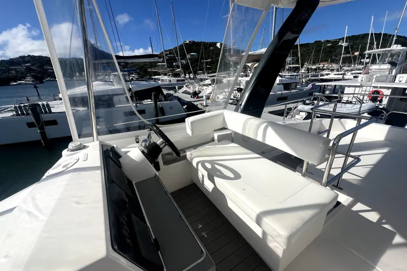  Yacht Photos Pics 2020 Leopard 43 Powercat yacht helm station with white seating, docked in a marina.