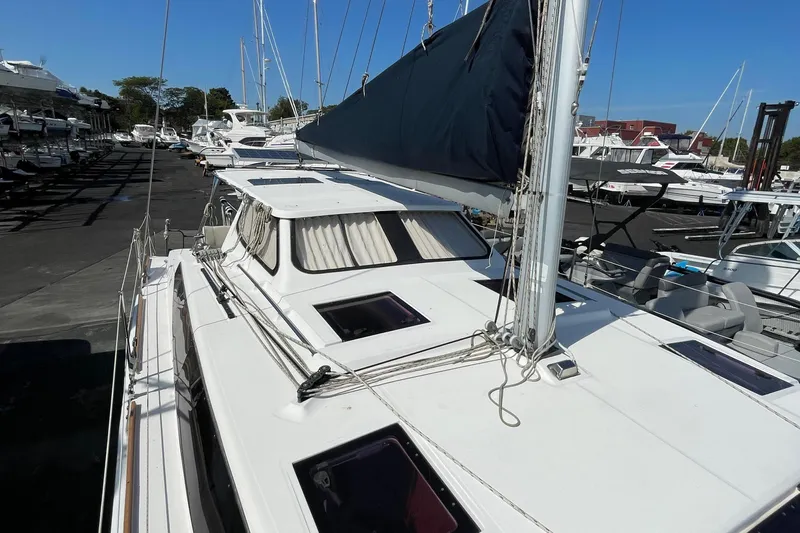  Yacht Photos Pics 2013 Gemini Legacy sailboat docked in a marina, featuring a sleek white design and covered sails.