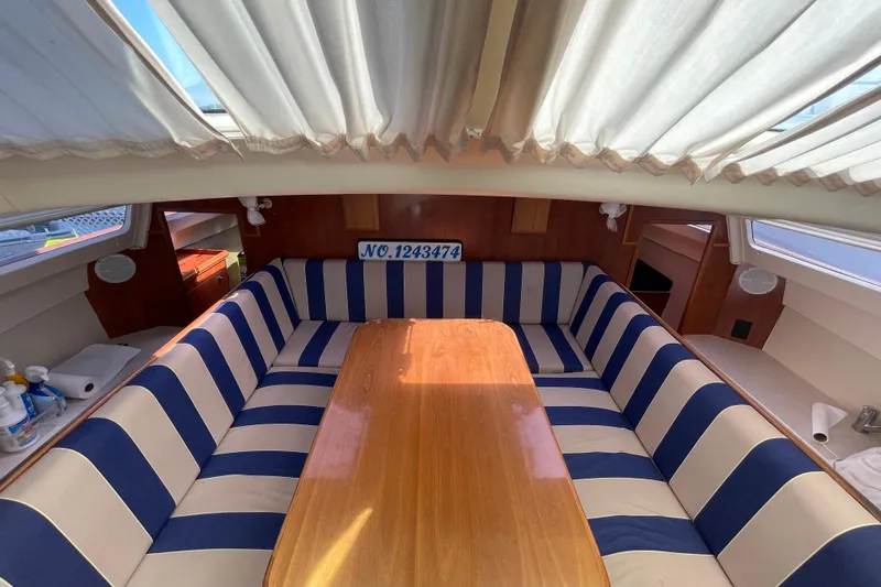  Yacht Photos Pics Interior of 2013 Gemini Legacy boat with striped seating and wooden table.