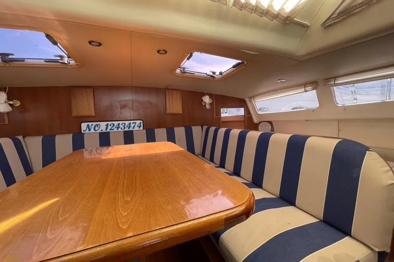  Yacht Photos Pics Interior of 2013 Gemini Legacy boat with striped seating and wooden table.