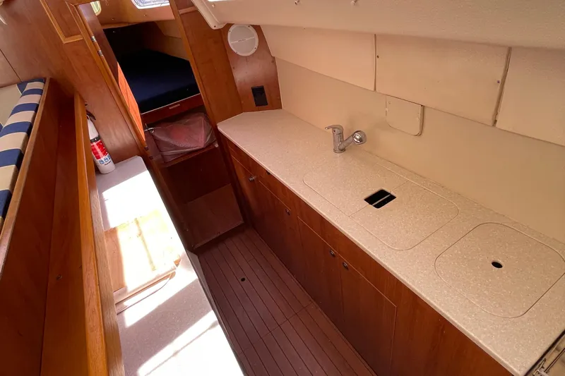  Yacht Photos Pics Interior of 2013 Gemini Legacy boat with wooden cabinetry and compact kitchen area.