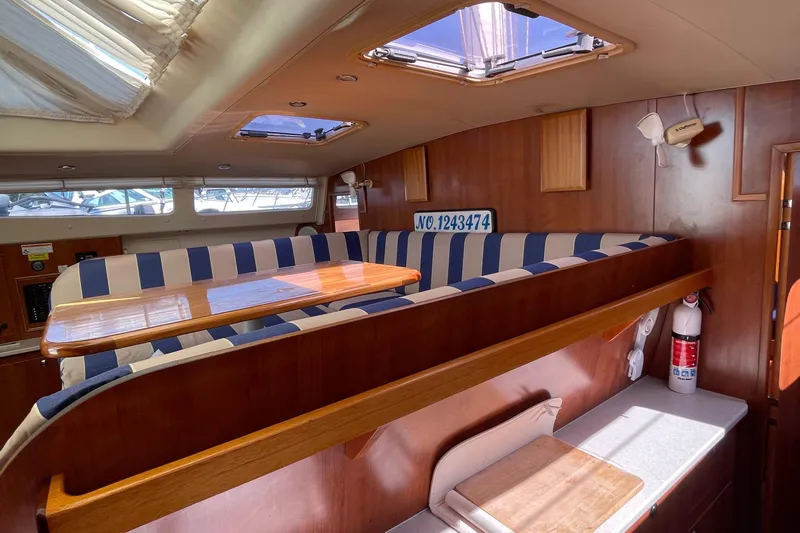  Yacht Photos Pics Interior of 2013 Gemini Legacy boat with striped seating and wooden table.