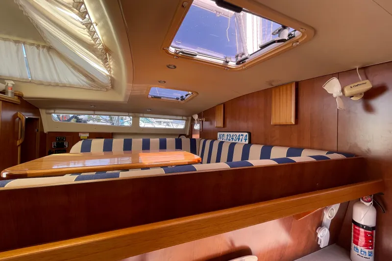  Yacht Photos Pics Interior of 2013 Gemini Legacy boat with striped seating and wooden table.