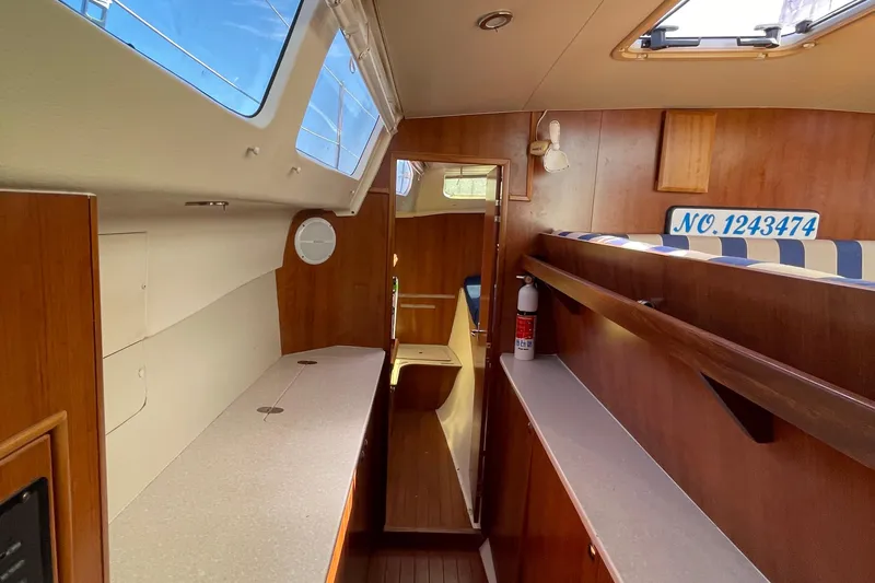  Yacht Photos Pics Interior of 2013 Gemini Legacy boat with wood finish and striped seating.