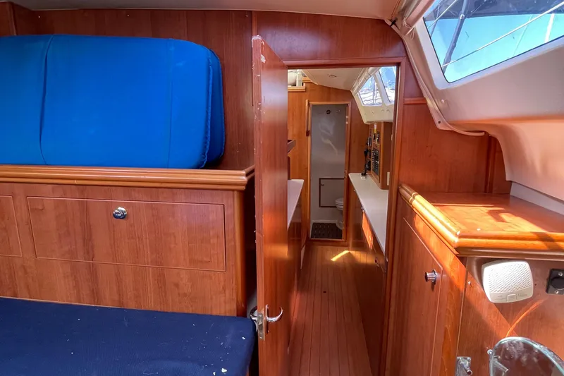 Yacht Photos Pics Interior of 2013 Gemini Legacy boat with wooden cabinetry and blue seating.