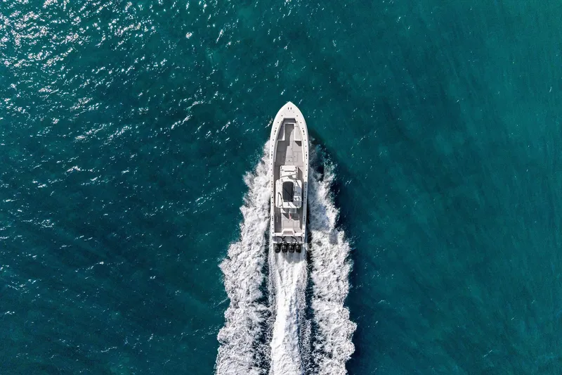  Yacht Photos Pics Aerial view of 2013 Invincible 42 Open Fisherman boat cruising on blue ocean waters.