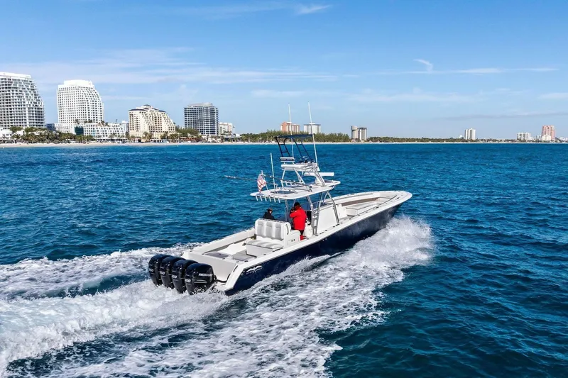  Yacht Photos Pics 2013 Invincible 42 Open Fisherman cruising on the ocean near a city.