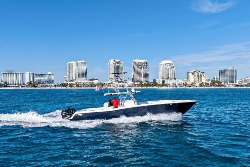  Yacht Photos Pics Invincible 42 Open Fisherman boat cruising near city skyline, 2013 model.