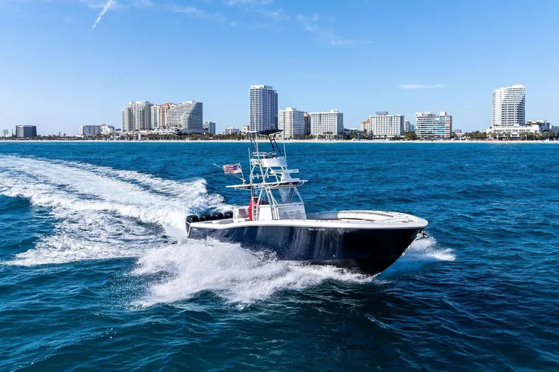  Yacht Photos Pics Invincible 42 Open Fisherman boat cruising on the ocean near coastline.