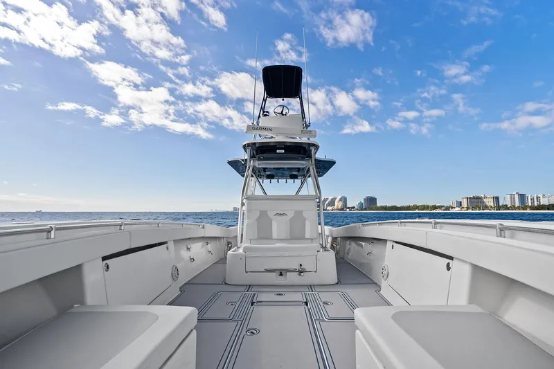  Yacht Photos Pics 2013 Invincible 42 Open Fisherman boat on open water, clear sky, city skyline in background.