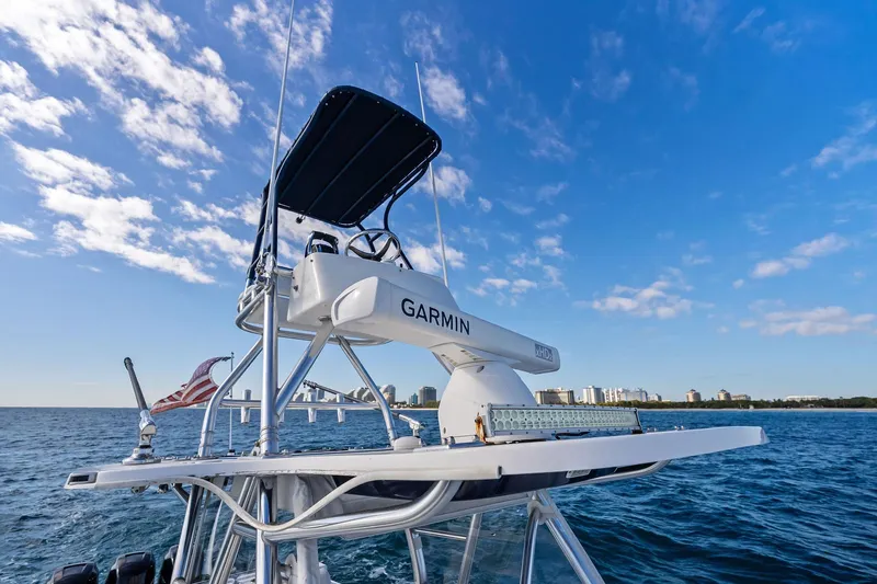  Yacht Photos Pics 2013 Invincible 42 Open Fisherman boat on ocean, clear sky, city skyline in background.