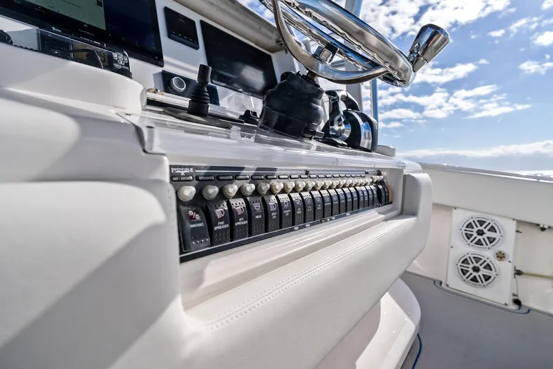  Yacht Photos Pics Control panel of 2013 Invincible 42 Open Fisherman boat with steering wheel and switches.