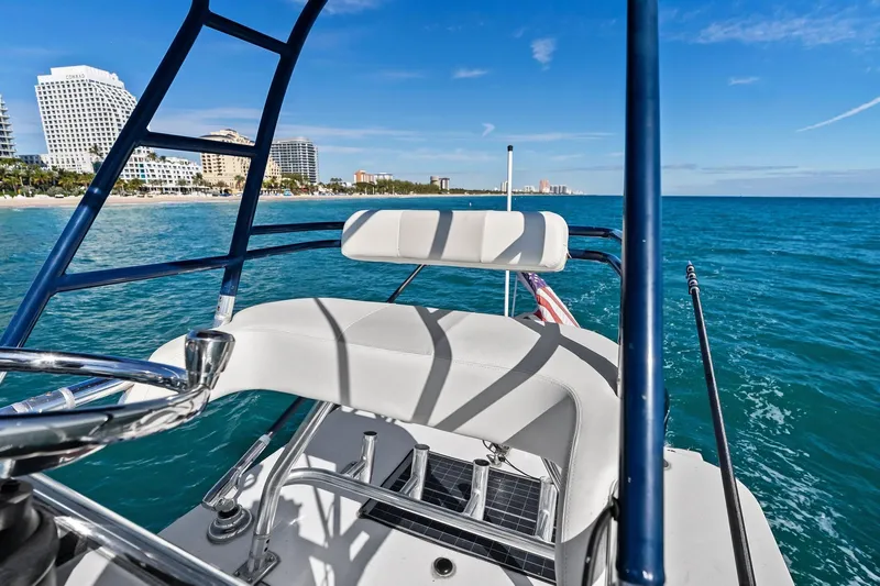  Yacht Photos Pics 2013 Invincible 42 Open Fisherman boat cruising near a coastal city skyline.