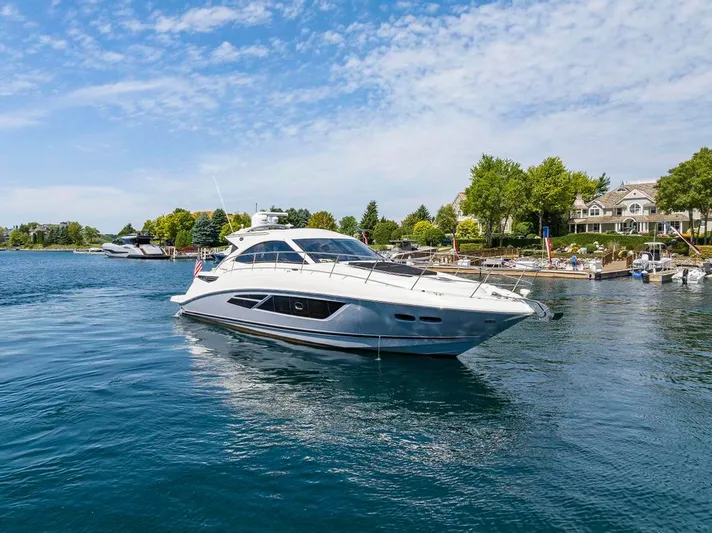  Yacht Photos Pics 2015 Sea Ray 510 Sundancer yacht cruising on a serene lake near a marina.