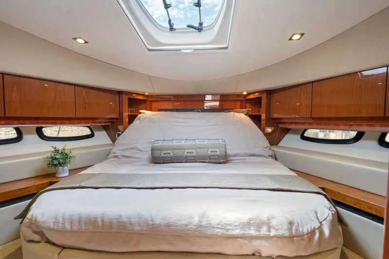  Yacht Photos Pics Luxurious bedroom interior of 2015 Sea Ray 510 Sundancer yacht with skylight and wood accents.