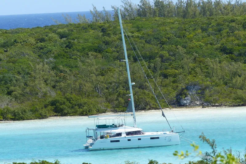 Nauti By Nature Yacht Photos Pics Sailing catamaran Nautitech 46 Fly 2017 anchored in turquoise waters near lush green island.