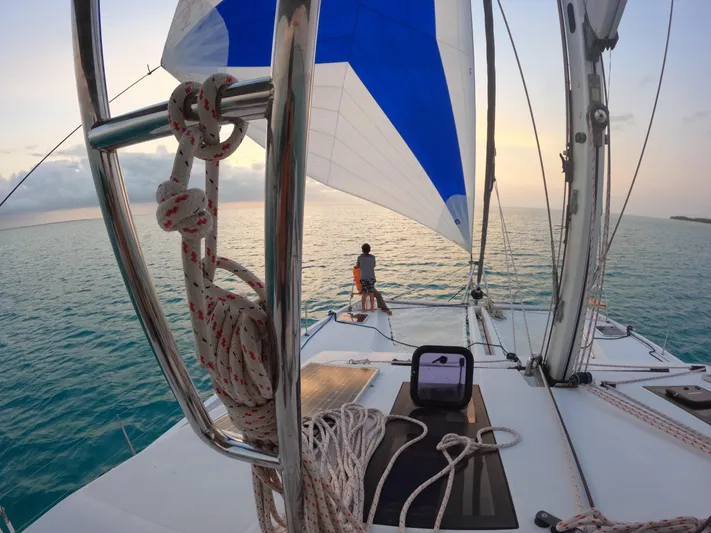 Nauti By Nature Yacht Photos Pics Sailing on a 2017 Nautitech 46 Fly catamaran at sunset, with a person enjoying the view.
