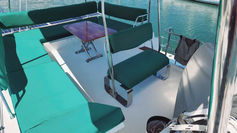 Nauti By Nature Yacht Photos Pics Flybridge seating area on a 2017 Nautitech 46 Fly catamaran, featuring green cushions and a wooden table.