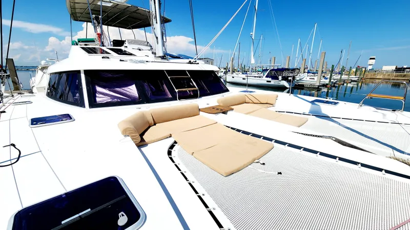 Nauti By Nature Yacht Photos Pics 2017 Nautitech 46 Fly catamaran with sun loungers, docked in a marina under clear blue skies.