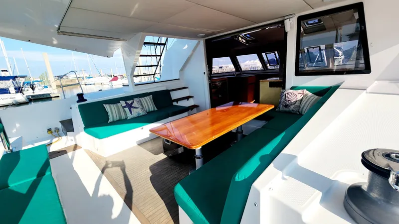 Nauti By Nature Yacht Photos Pics Spacious Nautitech 46 Fly 2017 yacht interior with green seating and wooden table.