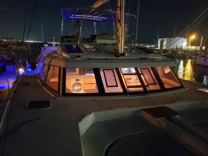 Nauti By Nature Yacht Photos Pics 2017 Nautitech 46 Fly catamaran docked at night, illuminated interior, marina background.