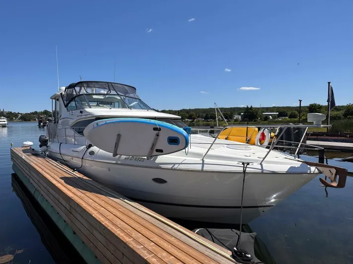  Yacht Photos Pics 2002 Cruisers Yachts 4450 Express Motor Yacht docked with paddleboard on deck.