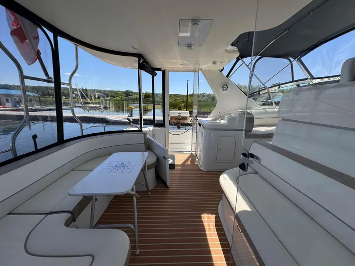  Yacht Photos Pics 2002 Cruisers Yachts 4450 Express Motor Yacht interior with seating and table, dockside view.