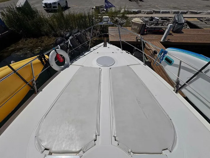  Yacht Photos Pics 2002 Cruisers Yachts 4450 Express Motor Yacht docked, view from bow with lifebuoy.