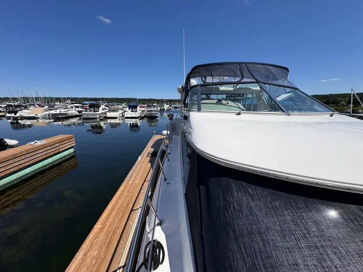  Yacht Photos Pics 2002 Cruisers Yachts 4450 Express Motor Yacht docked at marina under clear blue sky.