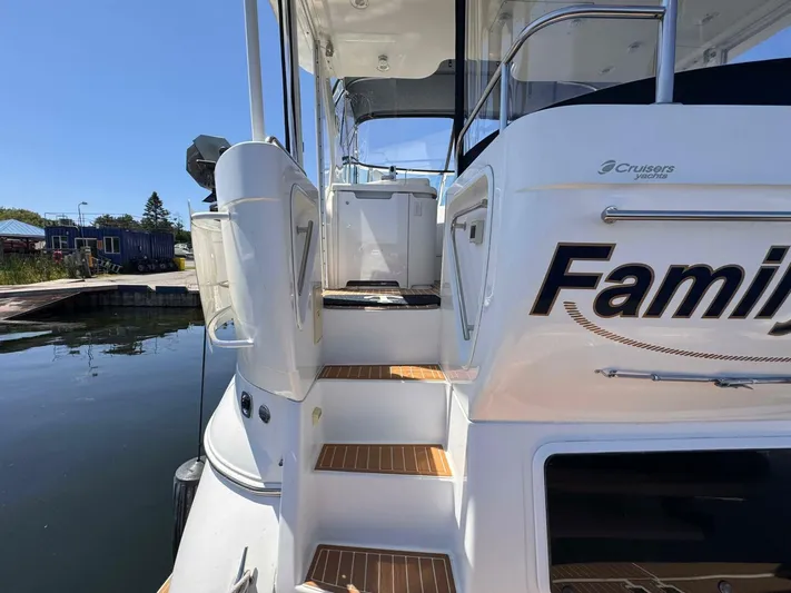  Yacht Photos Pics 2002 Cruisers Yachts 4450 Express Motor Yacht docked, showing rear entry steps and partial name.
