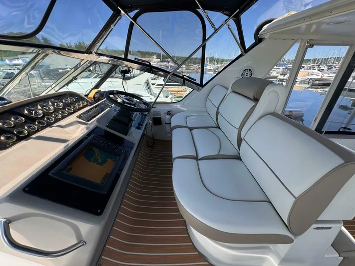  Yacht Photos Pics 2002 Cruisers Yachts 4450 Express Motor Yacht helm with white seating and navigation controls.