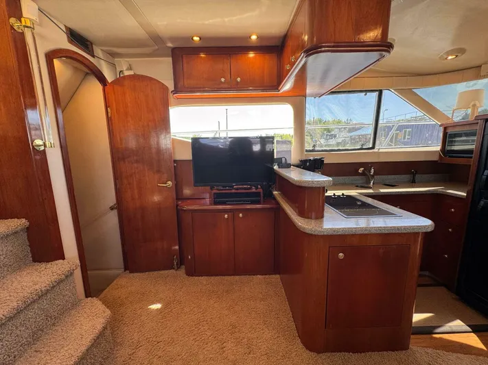  Yacht Photos Pics Luxurious 2002 Cruisers Yachts 4450 Express Motor Yacht interior with kitchen and entertainment area.