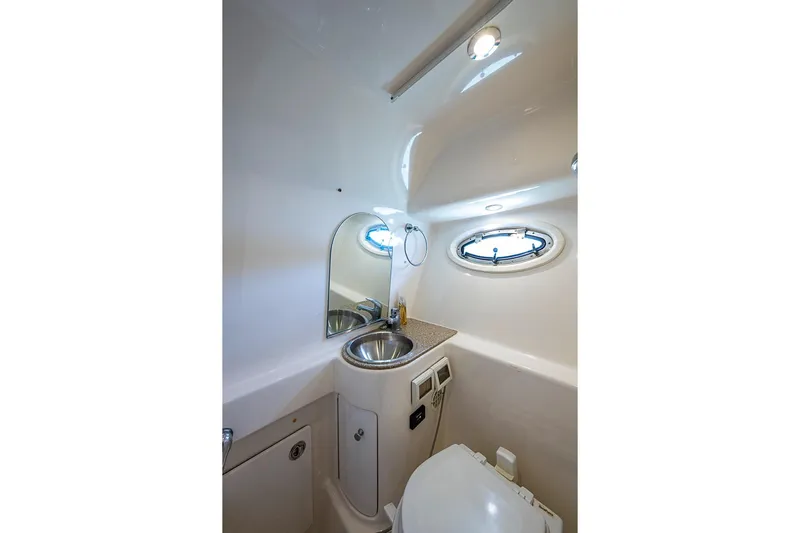 Float Me Alone Too Yacht Photos Pics Compact bathroom in 2012 Tiara Yachts 3100 Coronet with sink, mirror, and porthole.