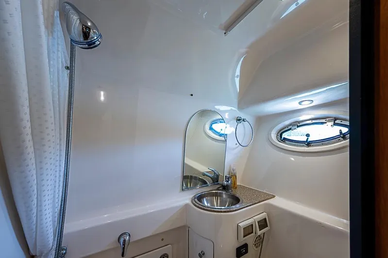 Float Me Alone Too Yacht Photos Pics 2012 Tiara Yachts 3100 Coronet bathroom with sink, mirror, and porthole window.