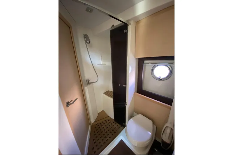  Yacht Photos Pics Bathroom interior of 2011 Beneteau Monte Carlo 47 Fly yacht, featuring shower and porthole.