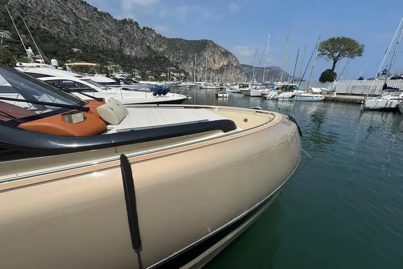  Yacht Photos Pics 2024 Invictus TT460 yacht docked in scenic marina with mountainous backdrop.
