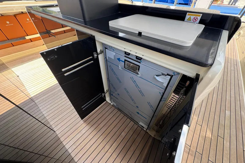  Yacht Photos Pics 2024 Invictus TT460 yacht interior with open cabinet and sleek black countertop.
