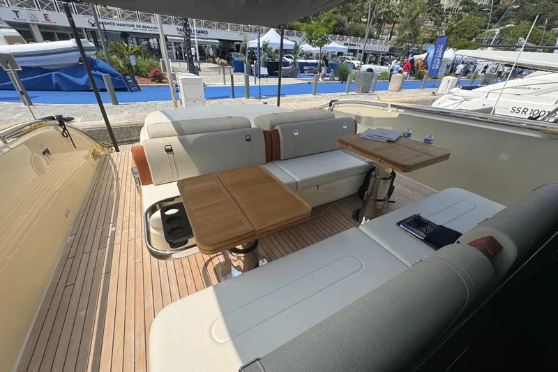  Yacht Photos Pics Luxurious seating area on 2024 Invictus TT460 yacht, featuring elegant wooden tables and plush upholstery.