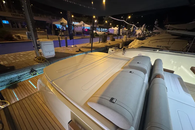  Yacht Photos Pics 2024 Invictus TT460 yacht at night, docked with illuminated deck and seating area.