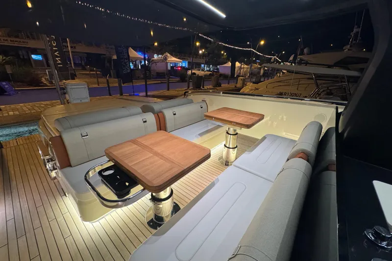  Yacht Photos Pics Luxurious 2024 Invictus TT460 yacht interior with elegant seating and wooden tables at night.