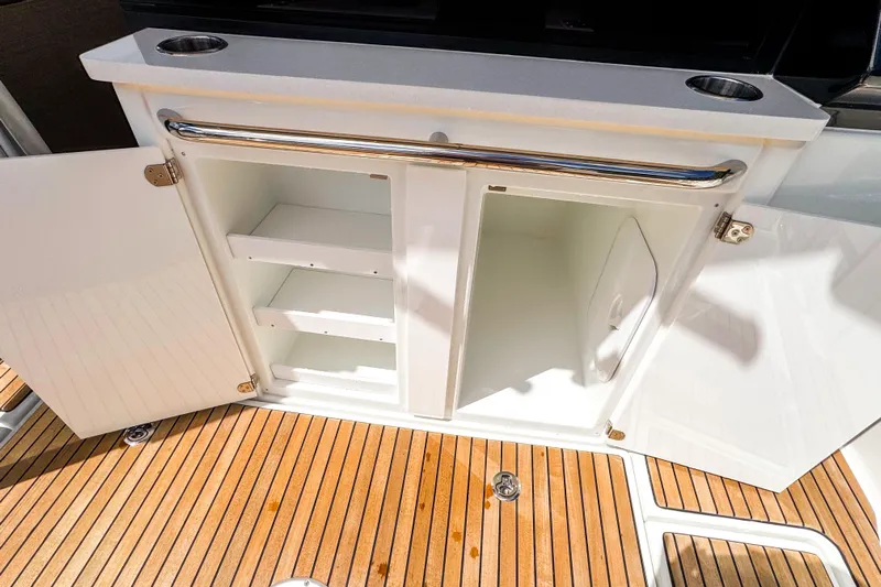  Yacht Photos Pics Open storage cabinet on 2025 Wellcraft 38 Explorer boat with wooden deck flooring.