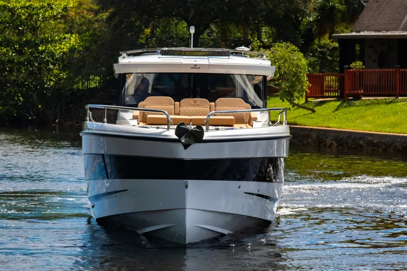  Yacht Photos Pics 2025 Wellcraft 38 Explorer boat cruising on a serene waterway, surrounded by lush greenery.