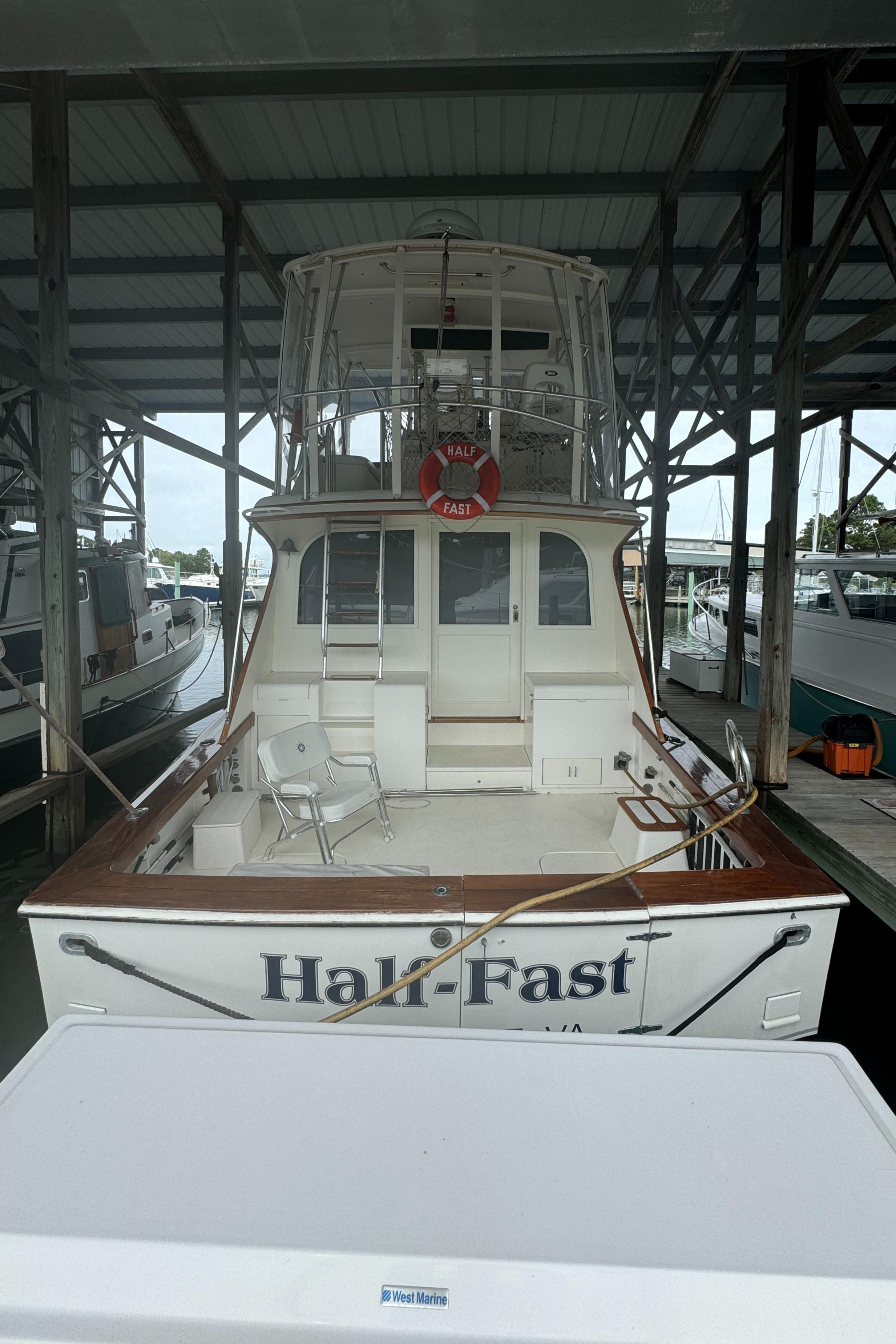1992 Post 46 Sportfish boat docked, rear view, under a covered marina.