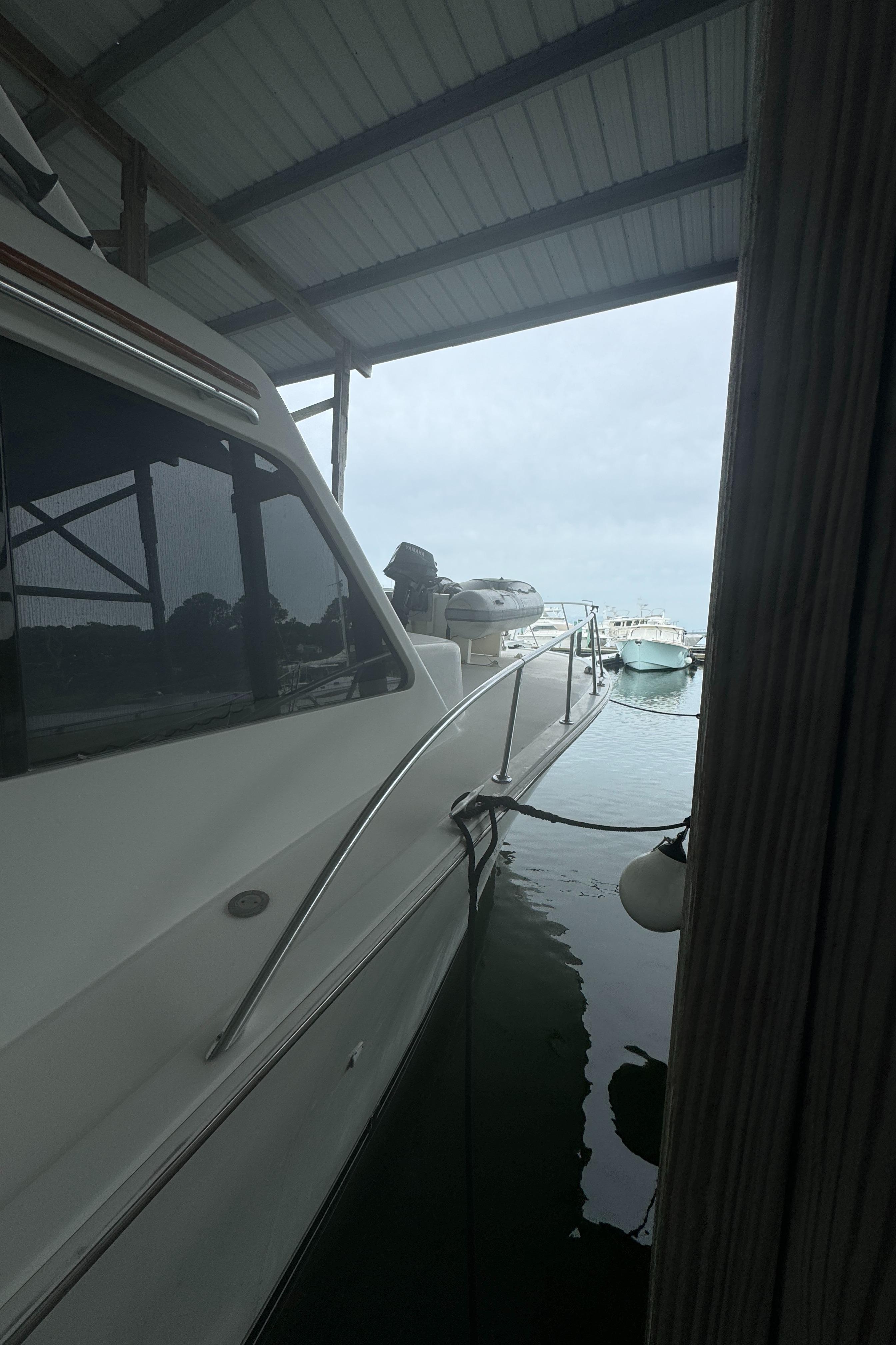 1992 Post 46 Sportfish yacht docked under a covered marina.
