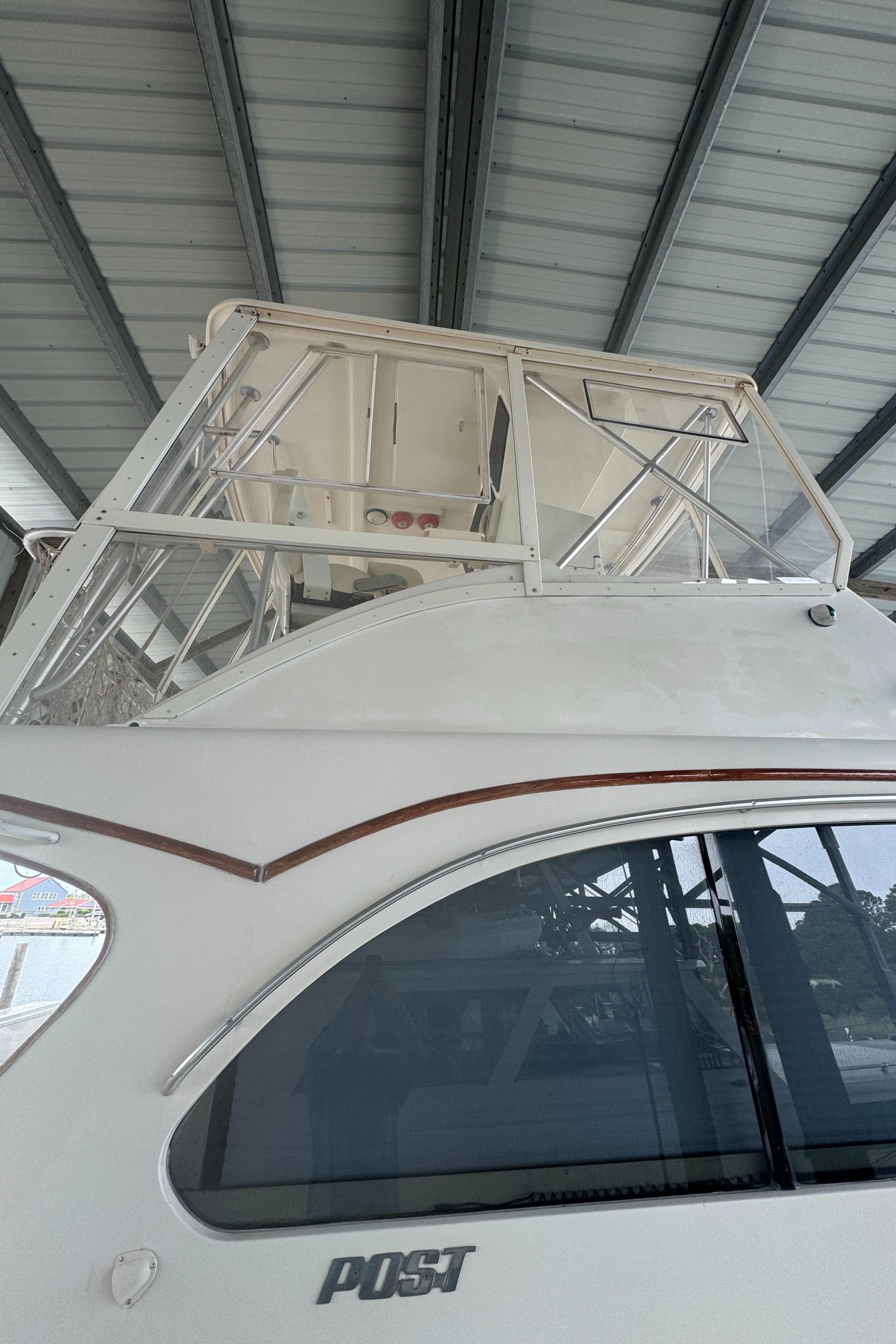 1992 Post 46 Sportfish boat under a metal roof, showcasing its upper deck and sleek design.