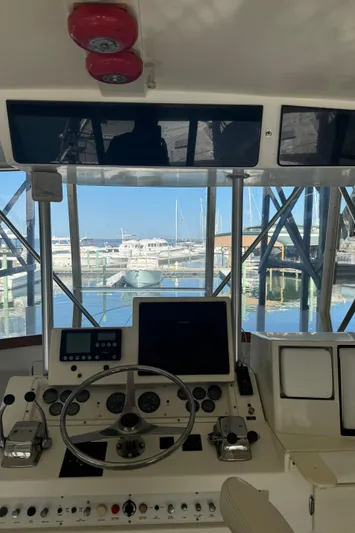 Half Fast Yacht Photos Pics 1992 Post 46 Sportfish helm with marina view, featuring steering wheel and control panels.
