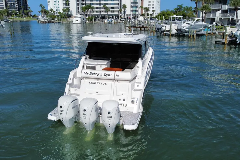  Yacht Photos Pics 2022 Regal 38 XO boat with triple Yamaha engines in a marina setting.