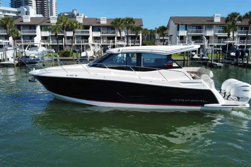  Yacht Photos Pics 2022 Regal 38 XO boat docked in marina with waterfront buildings.